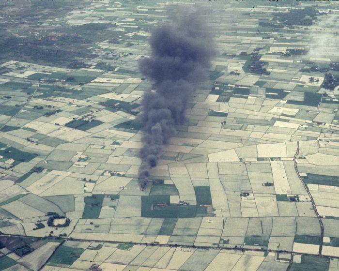 CH-47A Chinook helicopter 65-07989 as it lay in a rice patty burning after being shot down by enemy fire in the Republic of Vietnam.