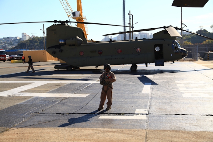 8 November 2013: Flight Engineer Wade Cothran stands by the Number One Engine of 11-08841 as the pilots prepare to start the aircraft. In the background, Standardization Instructor Tim Coffman crews 11-08838 as that aircraft prepares to start the engines.