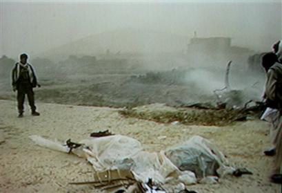 In this image taken from video, an Afghan inspects the wreckage of a U.S. military CH-47D Chinook helicopter.