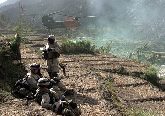 Soldiers of the 10th Mountain Division stand by as a CH-47 Chinook helicopter delivers supplies during Operation Mountain Resolve in Afghanistan. The Soldiers are searching for terrorists and anti-Coalition fighters in Afghanistan's Kunar and Nuristan Provinces.