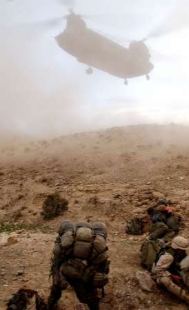 A CH-47 Chinook prepares to land for the extraction of Canadian ground security forces.