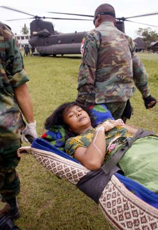 Singapore soldiers carry an earthquake victim to a Singapore Air Force Chinook helicopter at Gunungsitoli on the Indonesian island of Nias. Children on the quake-hit Indonesian island of Nias tried to return to schools on Monday, only to find many destroyed and some teachers afraid to resume classes as aftershocks rattled damaged buildings.