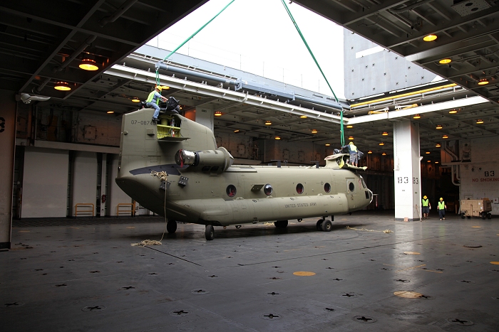 18 November 2010: CH-47F Chinook helicopter 07-08740 sits in the center hole of the USNS Mendonca as it is rigged with a sling for movement by crane down to the dock at Pearl Harbor.