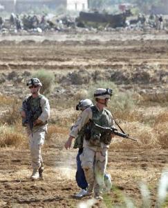 U.S. soldiers observe the scene after a U.S. Chinook helicopter (center, background) believed carrying dozens of soldiers to leaves abroad was struck by a missile and crashed west of Baghdad, near Fallujah, on Sunday, 2 November 2003, killing 15 soldiers and wounding 26 others, the U.S. command and witnesses reported.