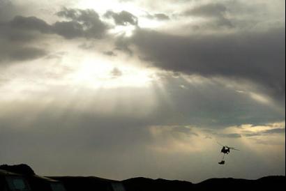 A British Chinook transport helicopter carries equipment near Camp Blair-Mayne in the desert of northern Kuwait on Monday, 3 March 2003. British forces continue massing in the Kuwaiti desert in preparation for possible conflict with Iraq.