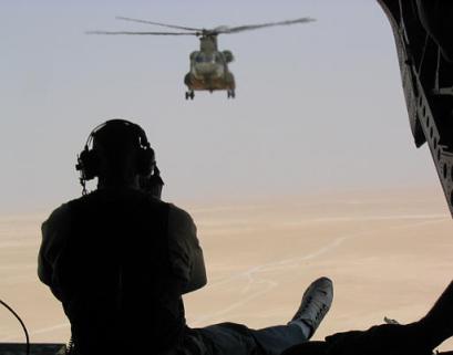 Miami Dolphins defensive end Jason Taylor rides on the ramp of a Chinook helicopter on Tuesday, 17 June 2003, on his way to Camp Udairi, Kuwait as part of Project Salute 2003 for the USO. Taylor is among several entertainers and celebrities visiting troops stationed in the Persian Gulf this week, as part of the USO's first large-scale entertainment tour since the war with Iraq began.