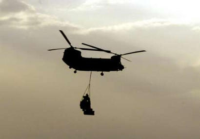 An RAF HC Mark II Chinook transport helicopter carries a bulldozer in the Kuwaiti desert on 3 March 2003.