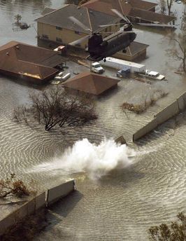 An Army National Guard CH-47D Chinook helicopter drops 15,000-pound bags of sand into a levee that gave way in New Orleans.