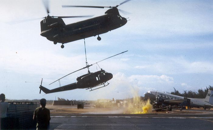 A 178th Assault Support Helicopter Company - "Boxcars" Chinook returns a damaged UH-1 Huey to Chu Lai in the Republic of Vietnam, circa 1967.